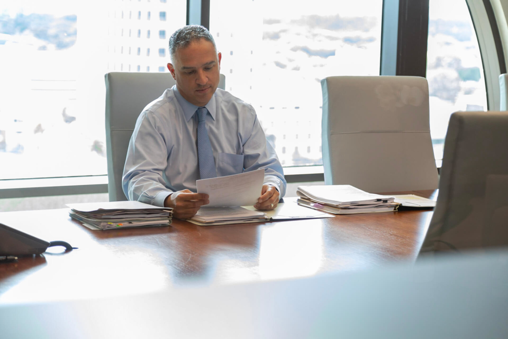 Man reading through paperwork at a conference table