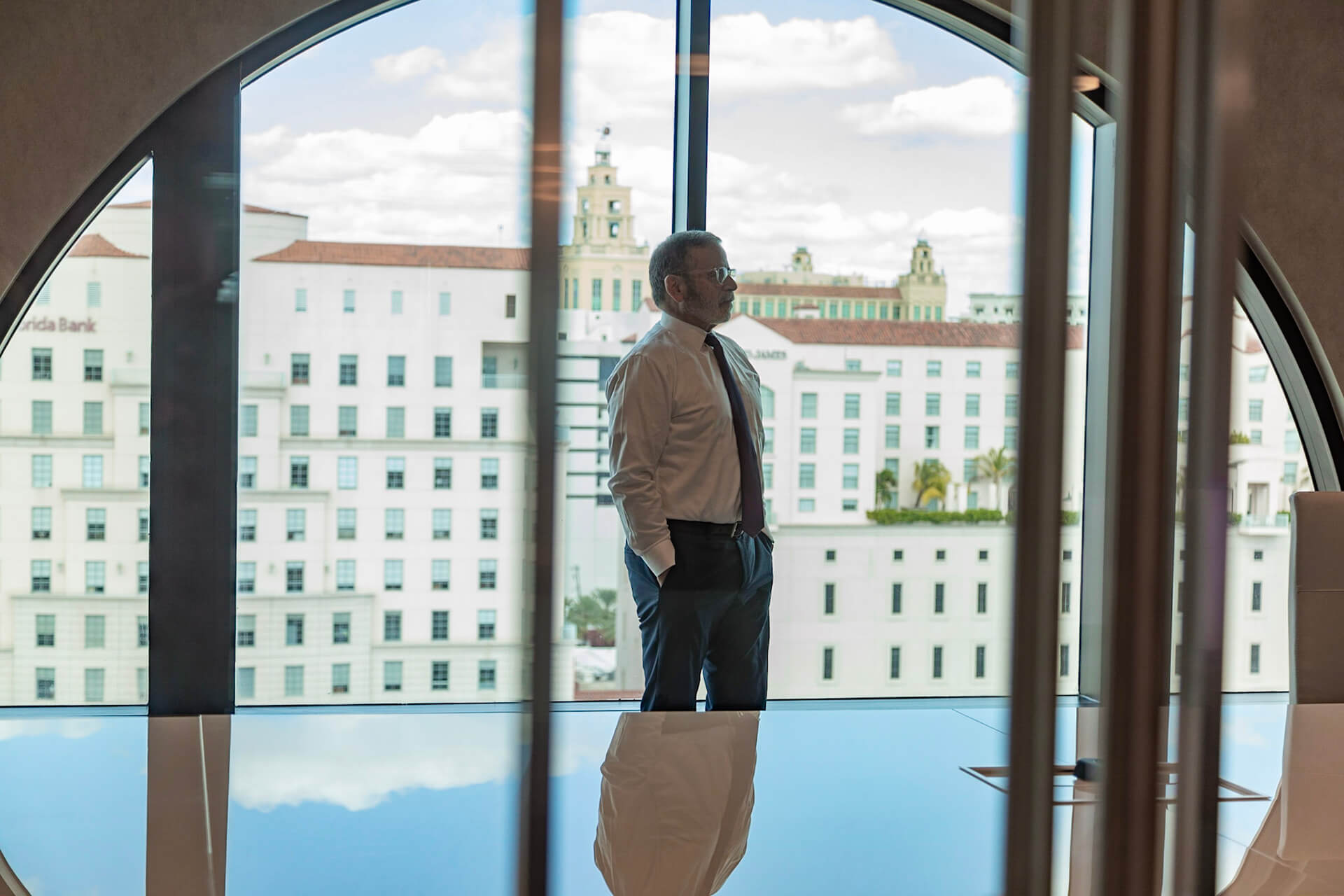 a man standing in front of large glass windows